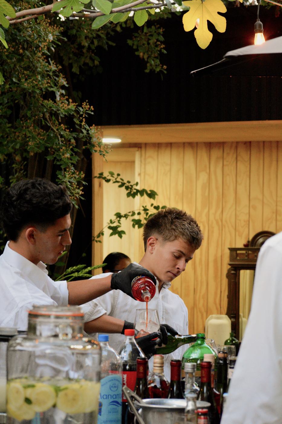 Dos bartenders preparando tragos en la barra