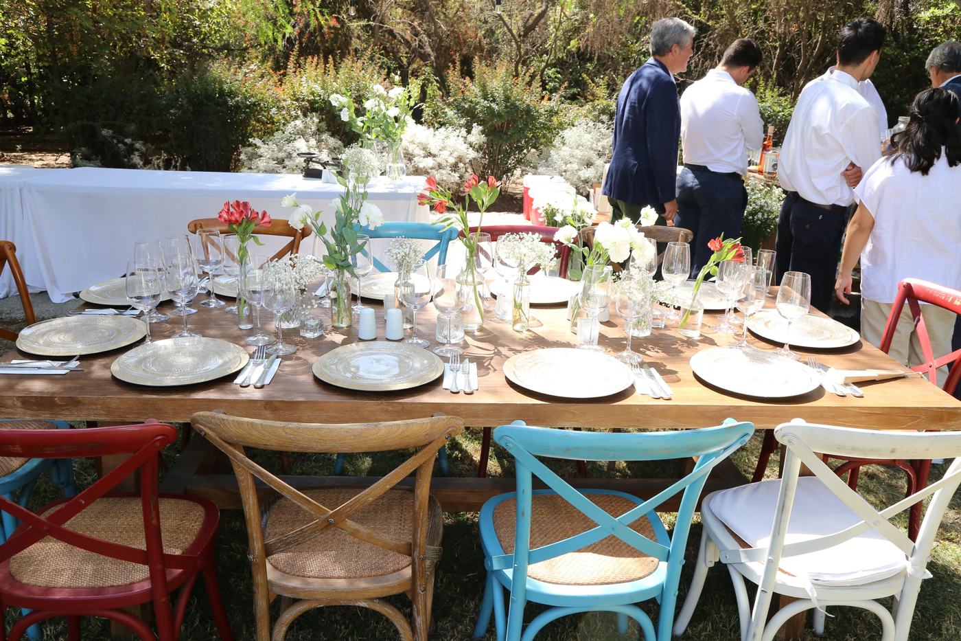 Montaje de mesa con sillas de colores en jardín