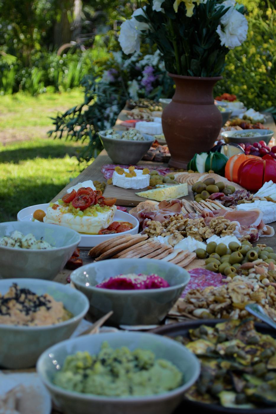 Mesa larga de picoteo en jardín
