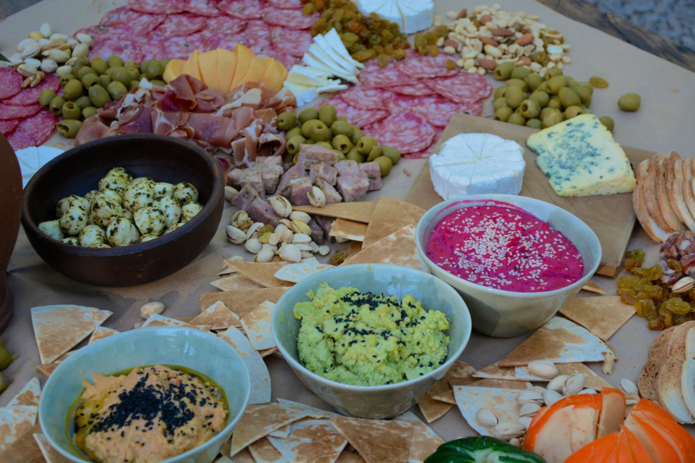 Mesa de picoteo con dips, hummus de betarraga y guacamole